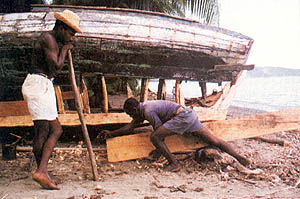 Haitian men repair a boat